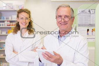 Pharmacist and his colleague with arms crossed behind