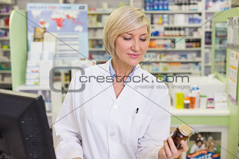 Pharmacist looking at medicine bottle