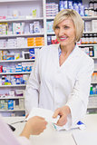 Pharmacist giving prescription to costumer