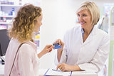 Pharmacist giving credit card to costumer