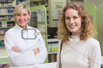 Pharmacist and customer looking at camera