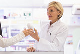 Smiling pharmacist and customer discussing a product