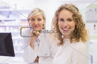 Pharmacist and costumer smiling at camera