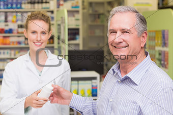 Pharmacist and costumer smiling a camera