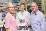 Pharmacist and costumers smiling at camera
