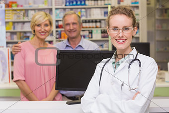 Pharmacist and costumers smiling at camera