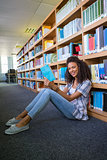 Student sitting on floor in library reading