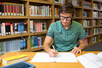 Student sitting in library writing