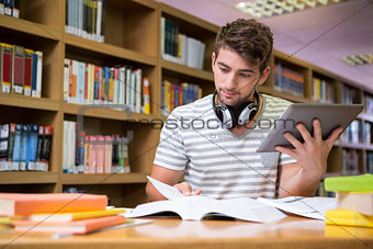 Student studying in the library with tablet