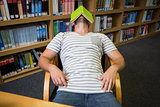 Student asleep in the library with book on his face