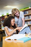 Student getting help from classmate in library