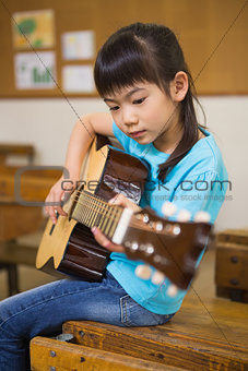 Cute pupil playing the guitar