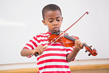 Focus pupil playing violin in classroom