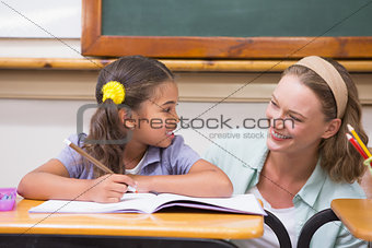 Teacher helping pupil in classroom