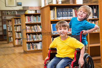 Cute pupils smiling at camera at the library