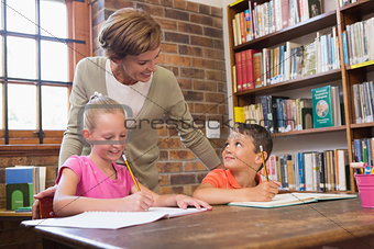 Teacher helping pupils in library
