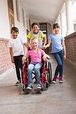 Cute disabled pupil smiling at camera with her friends