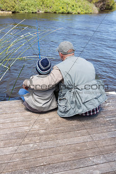 Father and son fihsing at a lake