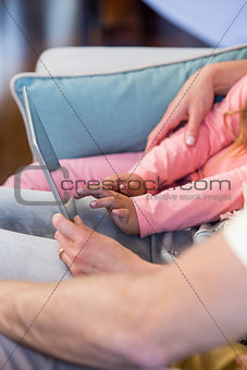 Family on the couch together using tablet pc