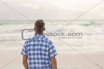Casual man looking out to sea