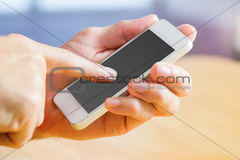 Hand holding a white smartphone