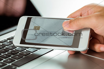 Man using laptop and phone for online shopping