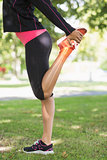 Highlighted leg of stretching woman
