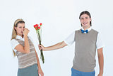 Geeky hipster offering red roses to his girlfriend