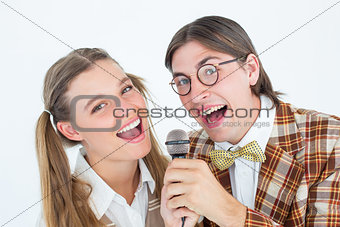 Happy geeky hipsters singing with microphone