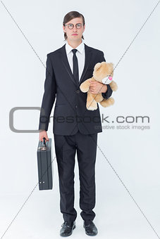 Geeky businessman holding briefcase and teddy