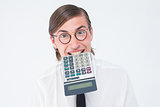Geeky smiling businessman biting calculator