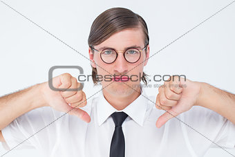 Geeky businessman looking at camera thumbs down