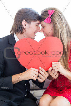 Cute geeky couple smiling and holding heart