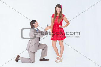 Hipster on bended knee doing a marriage proposal to his girlfriend