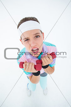 Hipster girl lifting dumbbells
