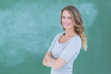 Smiling teacher standing in front of blackboard
