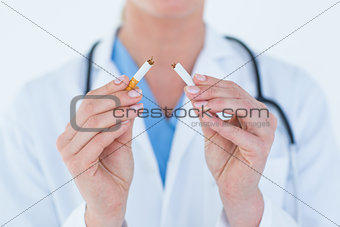 Doctor holding broken cigarette
