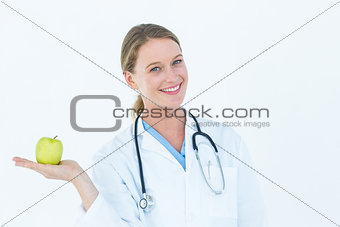 Smiling doctor offering an apple