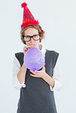 Geeky hipster blowing up balloon