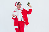 Geeky hipster in santa costume looking at mistletoe