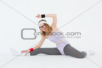 Geeky hipster stretching her legs on the floor