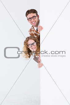 Geeky hipster holding poster and smiling at camera