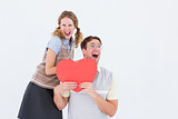 Excited geeky hipster couple with heart card