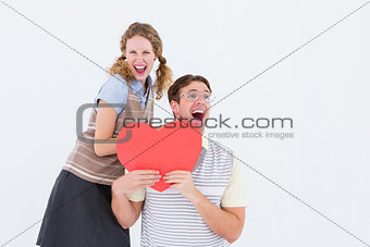 Excited geeky hipster couple with heart card