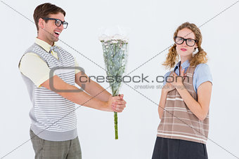 Geeky hipster offering flowers to his girlfriend