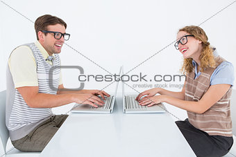 Geeky hipster couple using laptop