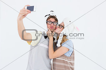 Geeky hipster couple taking selfie with smartphone
