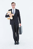 Geeky hipster businessman holding briefcase and teddy