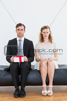 Geeky couple sitting on couch