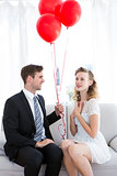 Businessman offering red balloons to his girlfriend